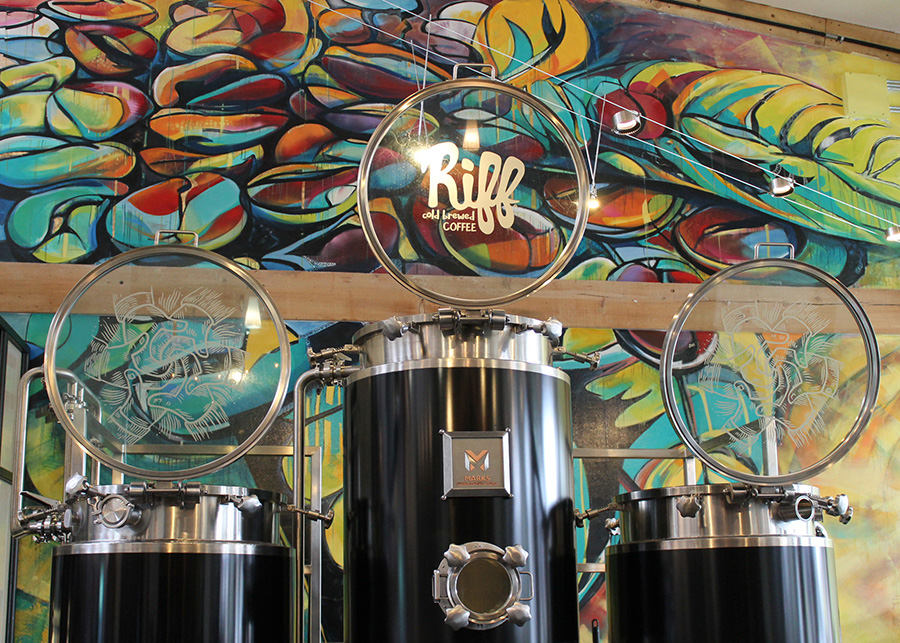 Large cold brew storage tanks on display behind the bar are backed by a custom collaboratively painted by the Bend Community